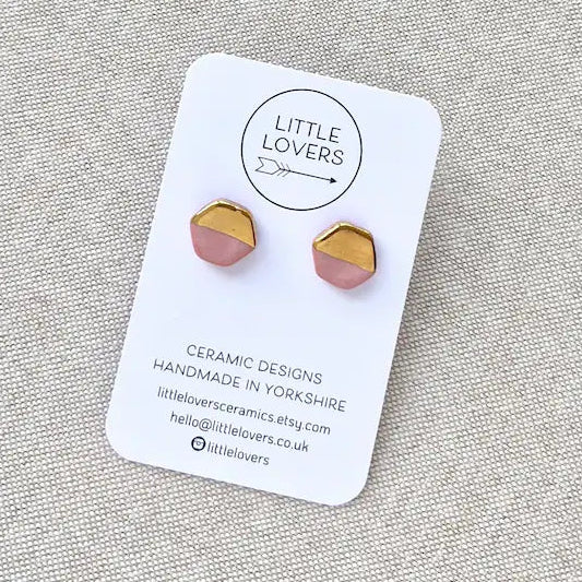 Ceramic earrings on a 'Little Lovers' branded card against a gray background