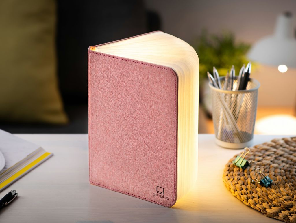 A clever concertina paged light which looks like a book. In linen texture and blush pink colour. When closed, 9W x 12.2H x 2.5cm